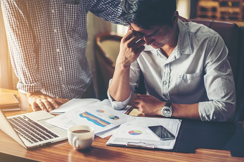 Serious young businessman looking at financial report seem like